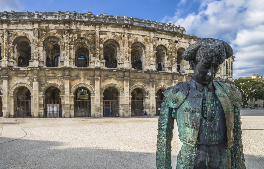 Roman Arena (Amphitheater) in Arles and bullfighter sculpture, Provence, France